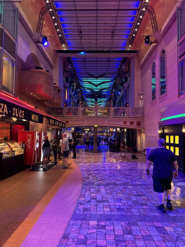 The Royal Promenade on Freedom of the Seas at night, with Sorrento’s pizza on the left
