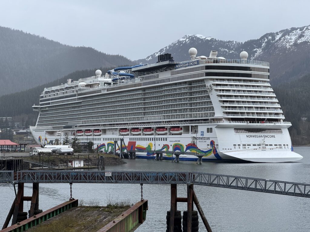 Norwegian Encore docked in Juneau, Alaska with snowy mountains behind