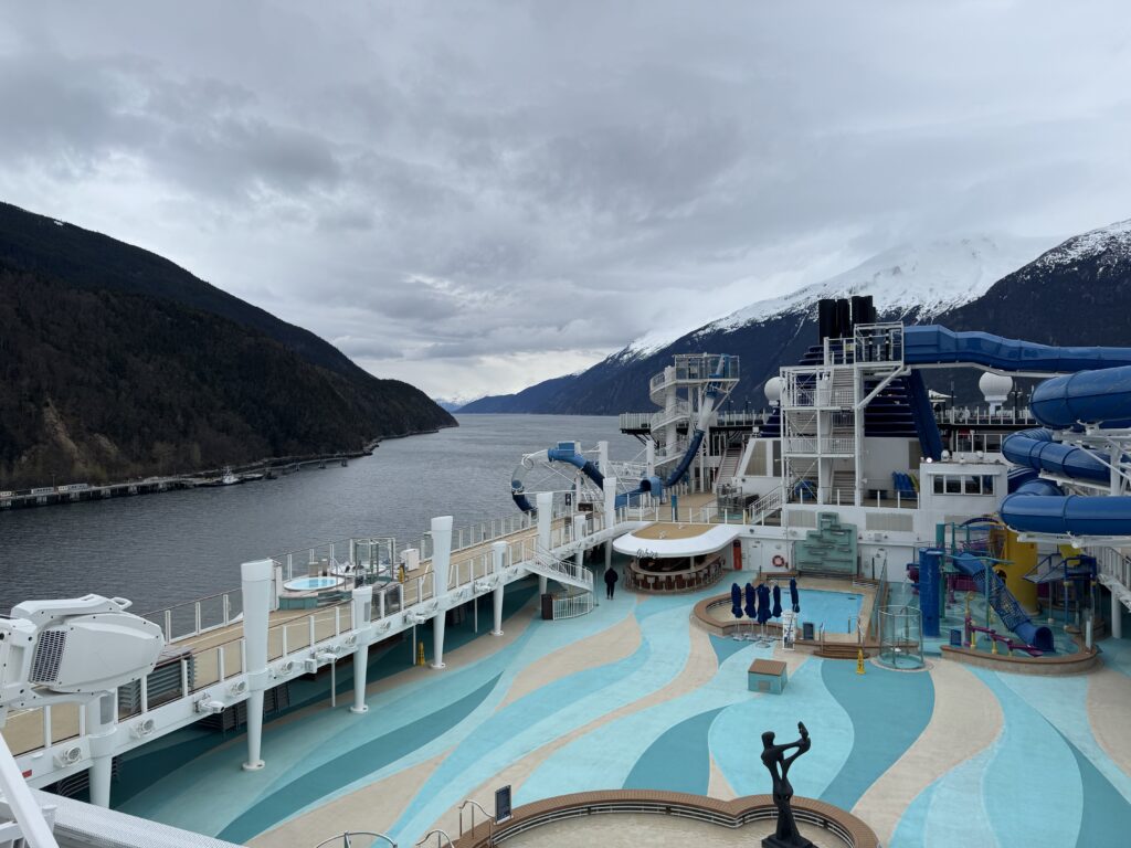 The deck of Norwegian Encore with mountains and water in Skagway, Alaska